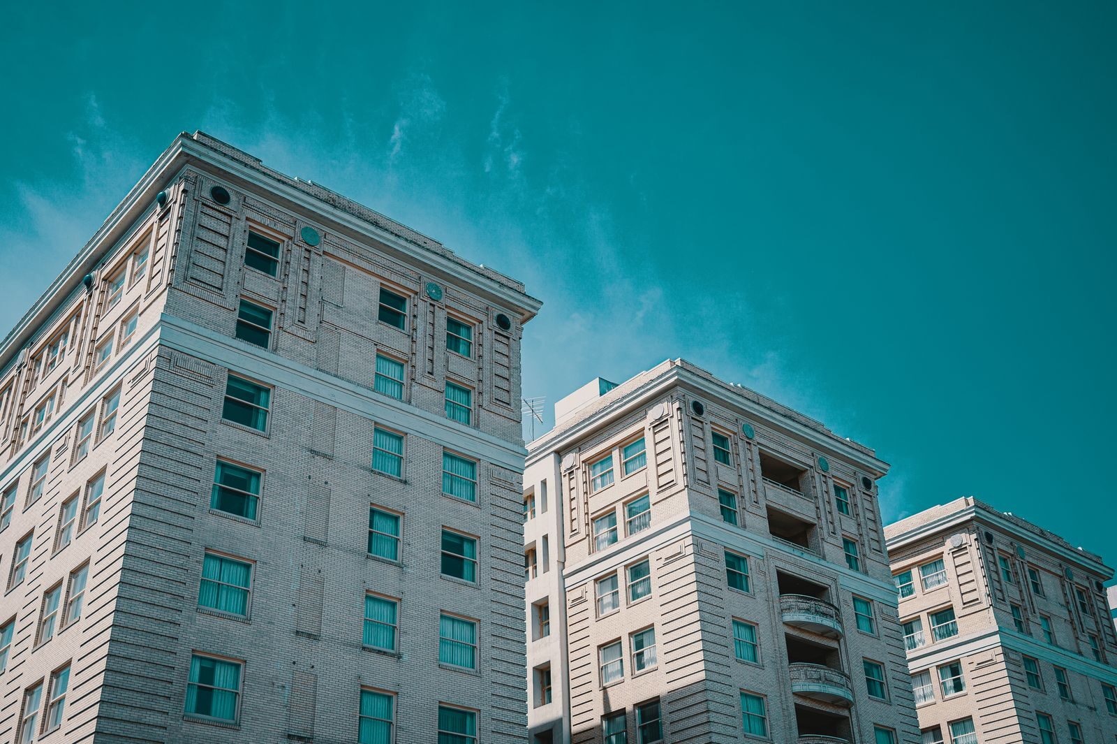 Elegant urban high-rise buildings with a vintage appeal under a clear sky.
